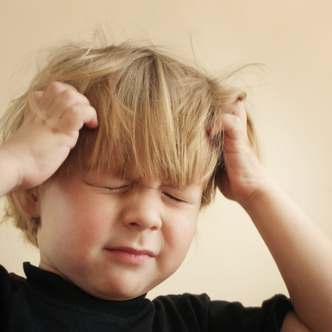 a child holding his head