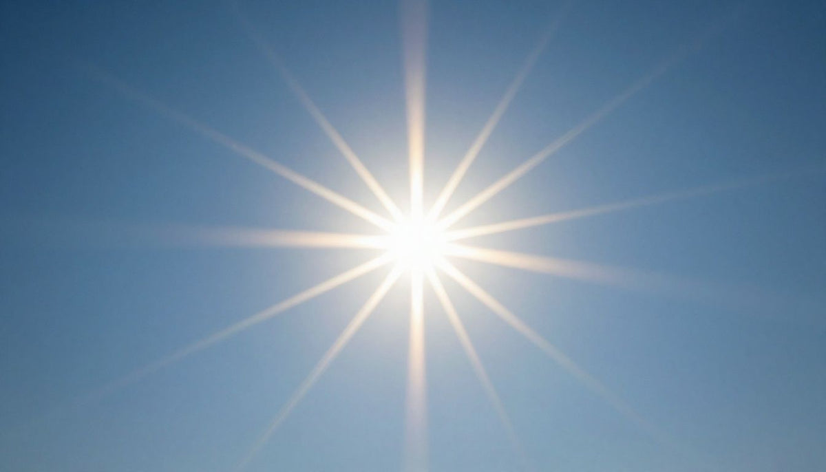 Sunbeams shining brightly in a clear blue sky.
