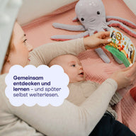 Baby mit Stofftier und Bilderbuch: gemeinsam entdecken und später selbst weiterlesen.