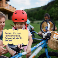 Kind mit rotem Fahrradhelm am Fahrrad: 200 ml für den Familienurlaub.