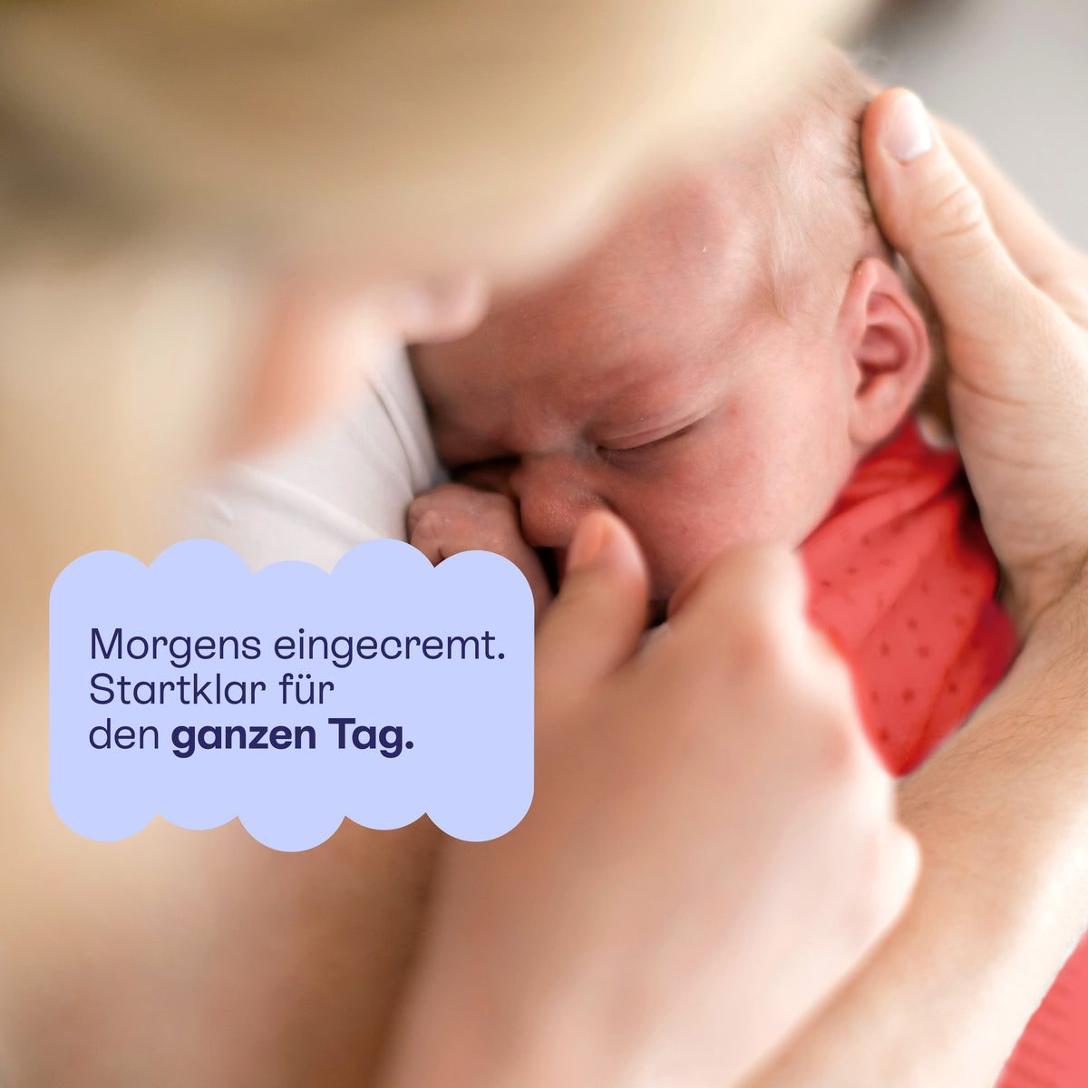 Ein Erwachsener cremt das Gesicht eines Babys: morgens eingecremt, stark für den ganzen Tag.