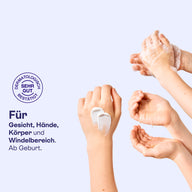 Hände mit Creme und Schaum aus dem Hallo Baby Set, für Gesicht, Hände, Körper und Windelbereich.