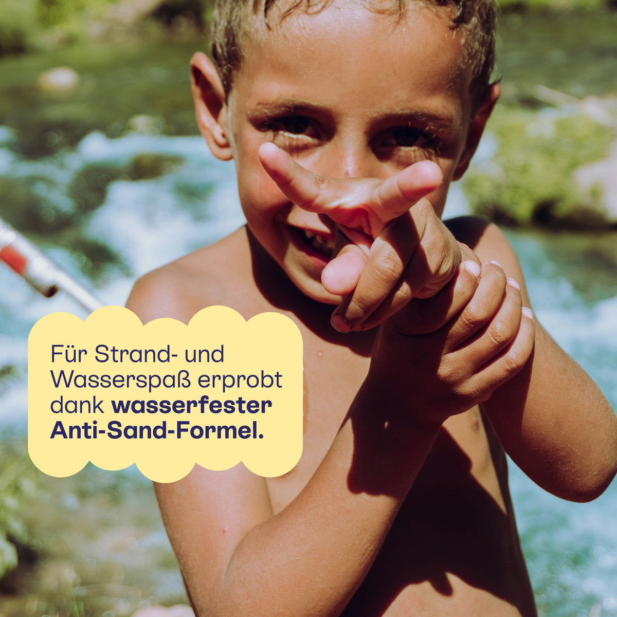 Junge mit Meeressonnencreme im Gesicht am Strand: wasserfeste Anti-Sand-Formel.