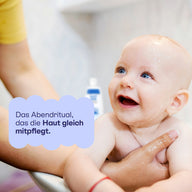 Lachendes Baby in der Badewanne: das Abendritual, das die Haut mitpflegt.