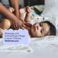 Baby wird am Bauch mit Pflegeöl massiert: Massage und hochwertige Pflege in einer Flasche.