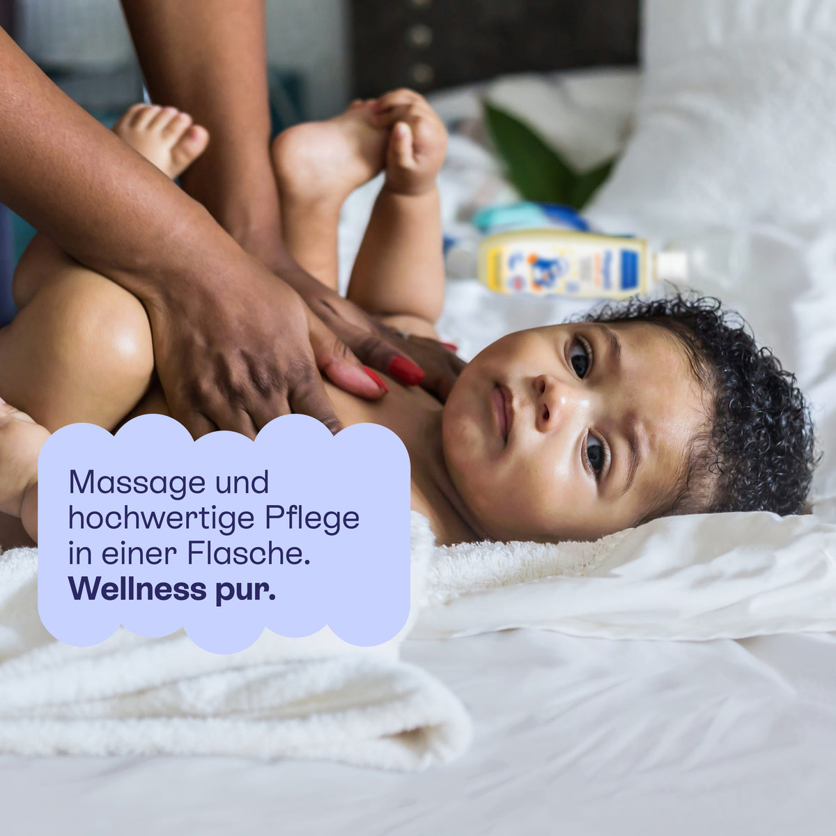 Baby wird am Bauch mit Pflegeöl massiert: Massage und hochwertige Pflege in einer Flasche.