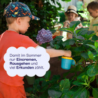 Kind mit Kappe im Garten: im Sommer zählt Eincremen, Rausgehen und Erkunden.