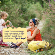 Mutter und Kind unterwegs mit dem Sprühkopf, ideal vor dem Kindergarten.