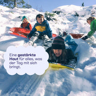 Kinder beim Rodeln im Schnee: eine gestärkte Haut für den Tag.
