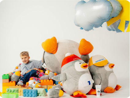 Kind mit Pauli-Kuscheltieren und Bauklötzen.