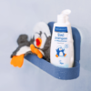 Eine feuchte PAEDIPROTECT 2in1 Shampoo & Waschlotion in der Dusche neben dem PAEDIPROTECT Waschlappen