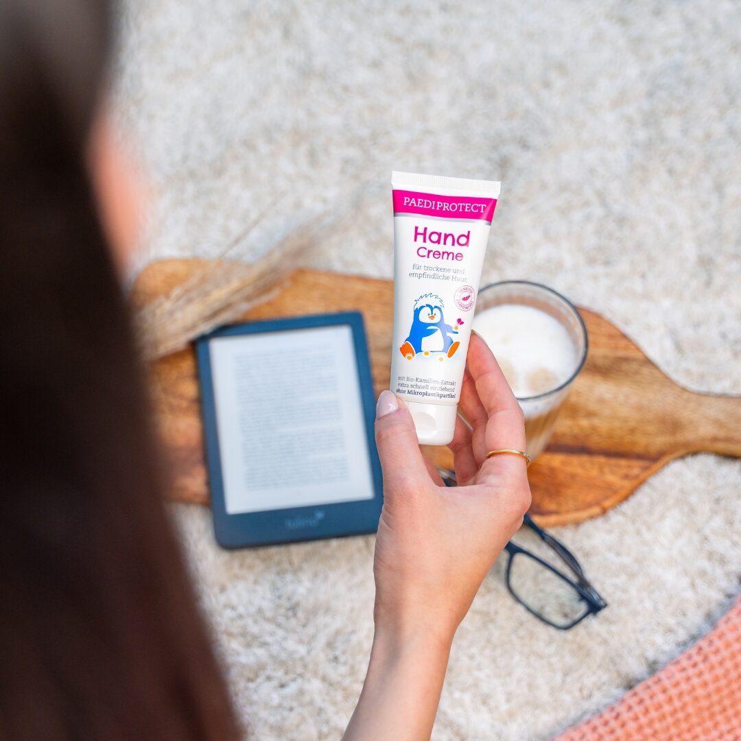 Handcreme 3 a cream tube and mittens on a blanket