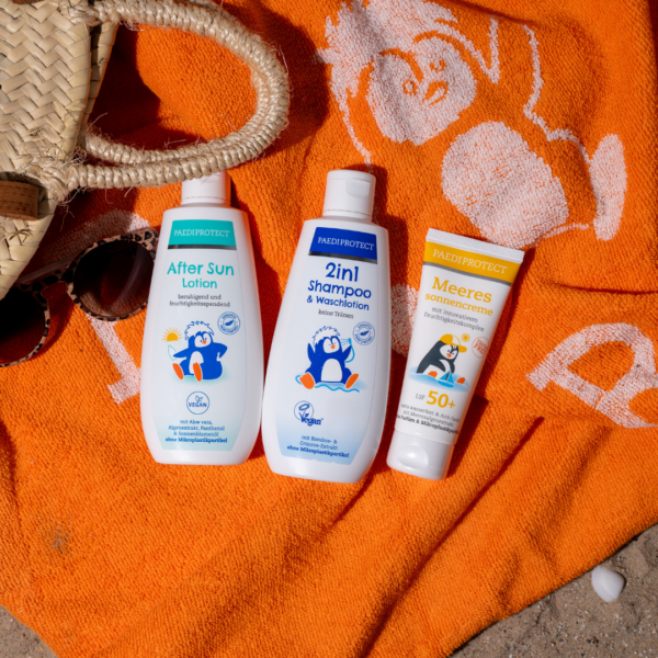 Meeressonnencreme, 2in1 Shampoo & Waschlotion, die After Sun Lotion auf dem Pauli-Badetuch auf den Sand gelegt