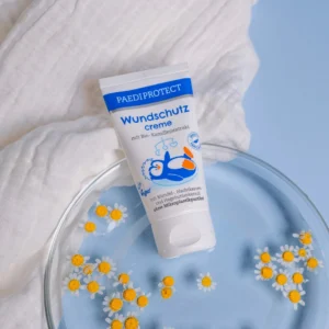 a tube of cream on a plate with flowers